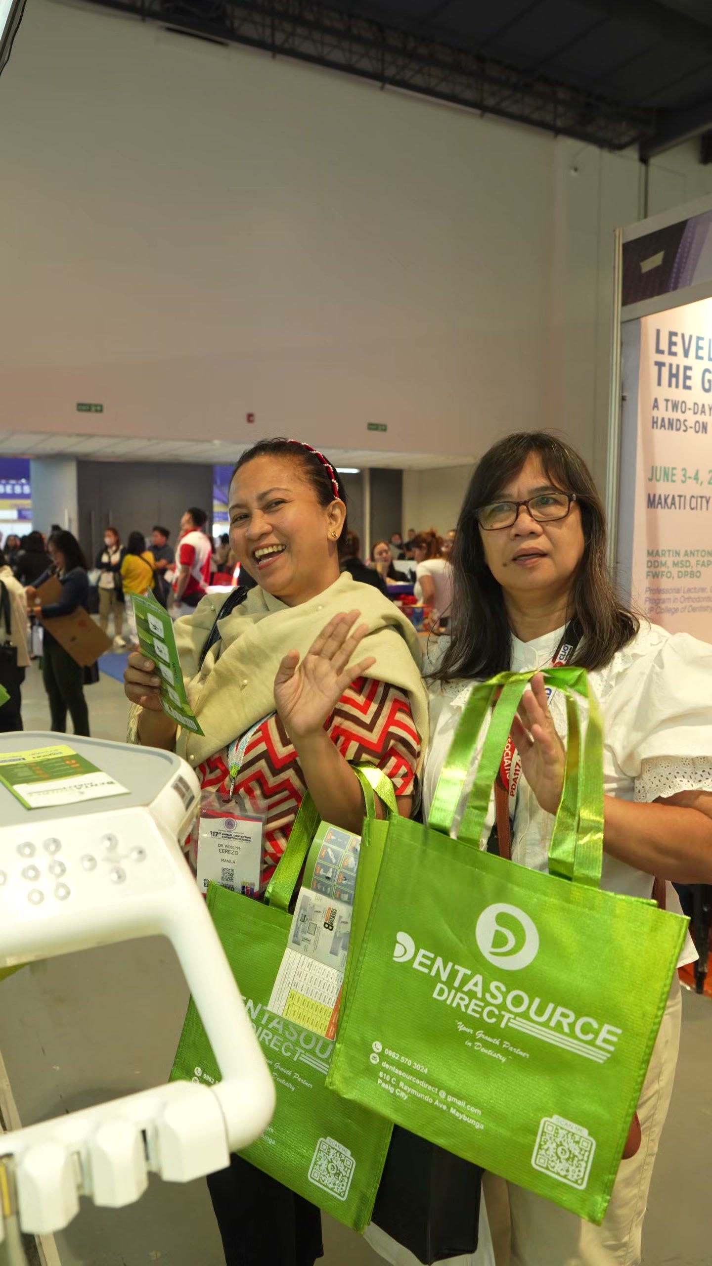 Dentists carrying DentaSource tote bags through the hall