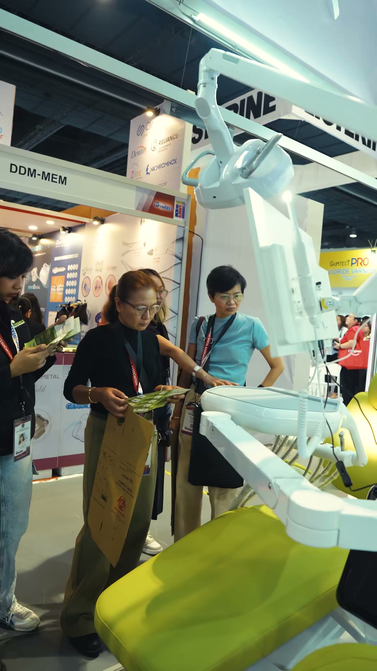 Dentists reading brochures beside the yellow upholstered chair