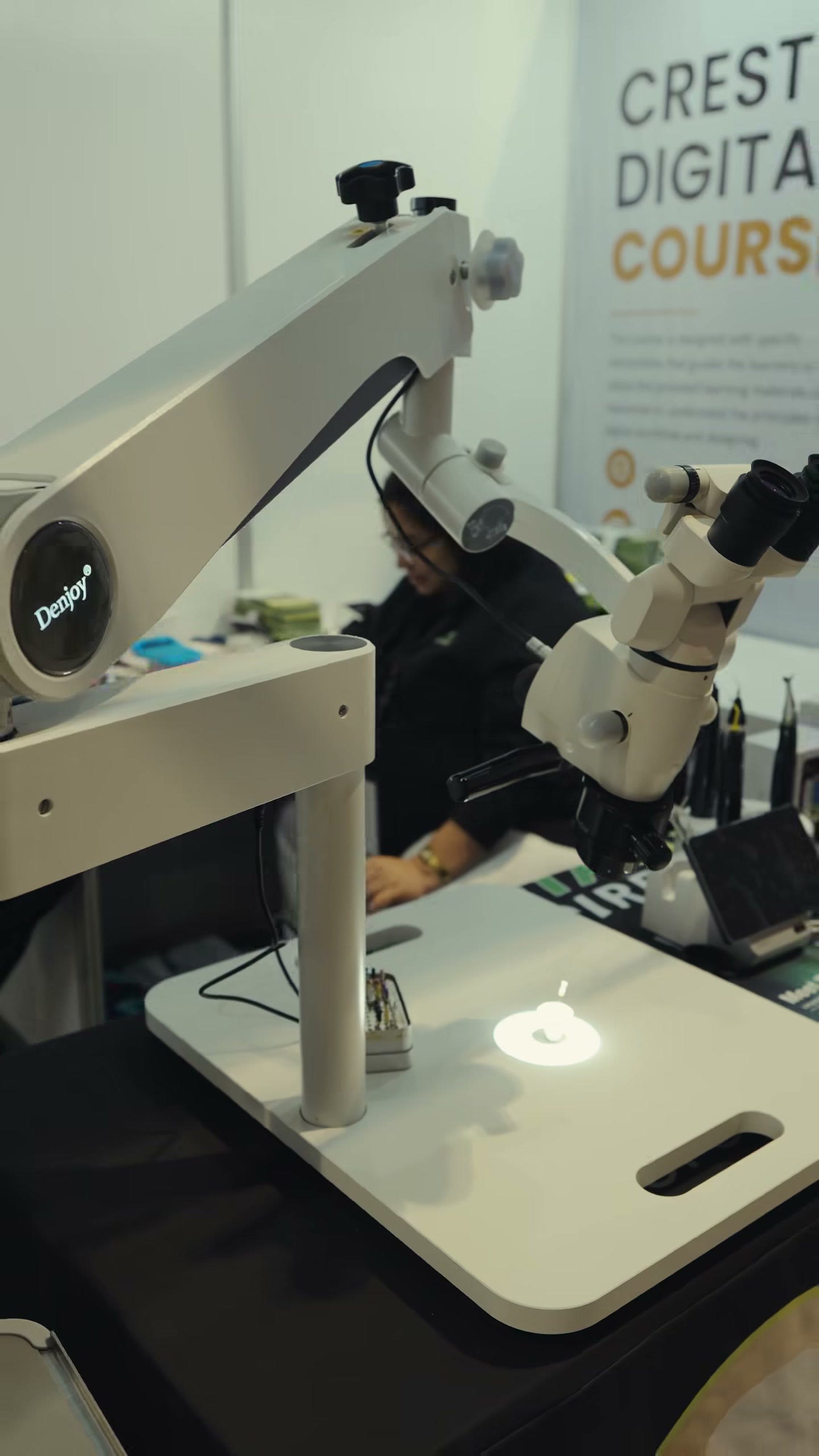 The surgical microscope beside the Crest Digital Course sign