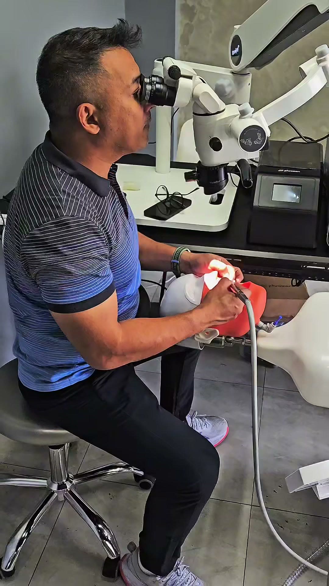 A trainee checking a printed model at the microscope