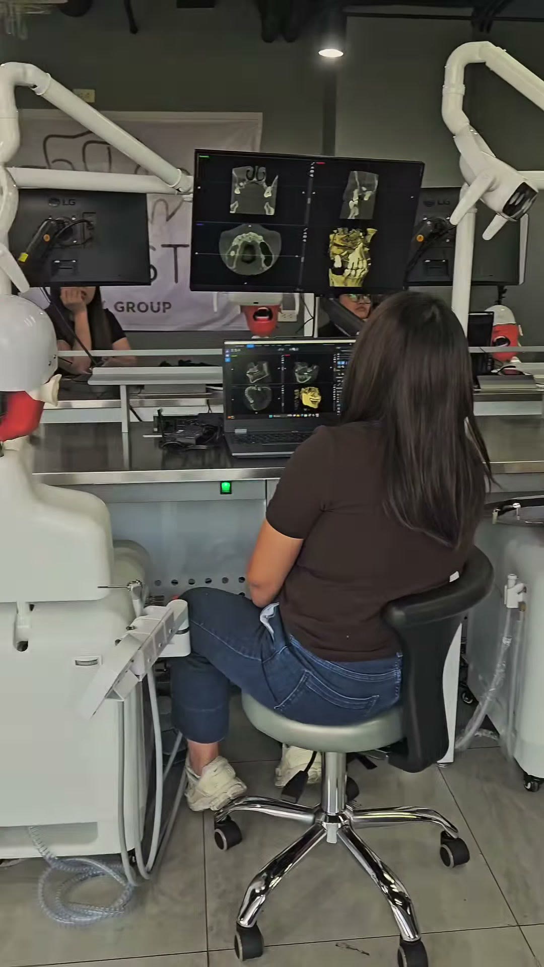 A trainee reviewing CBCT scans across dual monitors