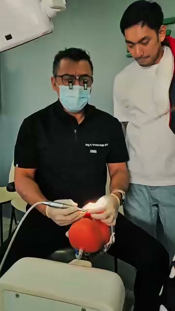 The Crest instructor in loupes working a handpiece on a phantom head