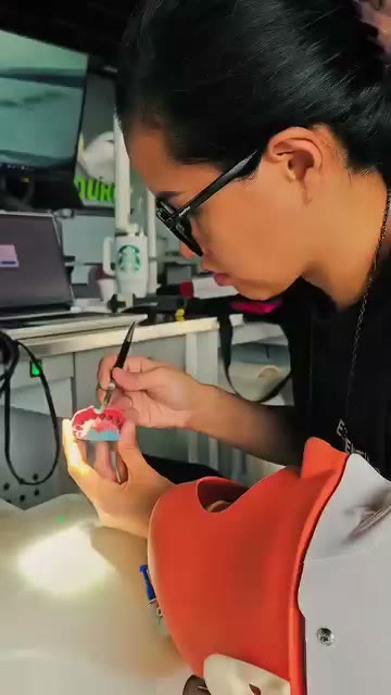 A trainee working a model at the bench
