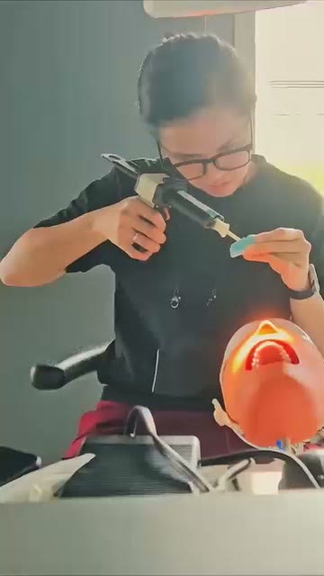 A trainee working in loupes at the simulator row