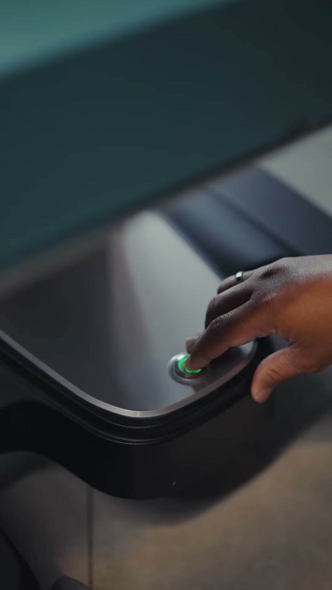 A finger pressing the button on the charging dock
