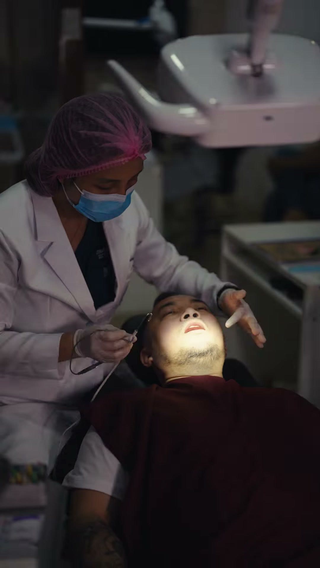 A dentist treating a patient with the workstation alongside
