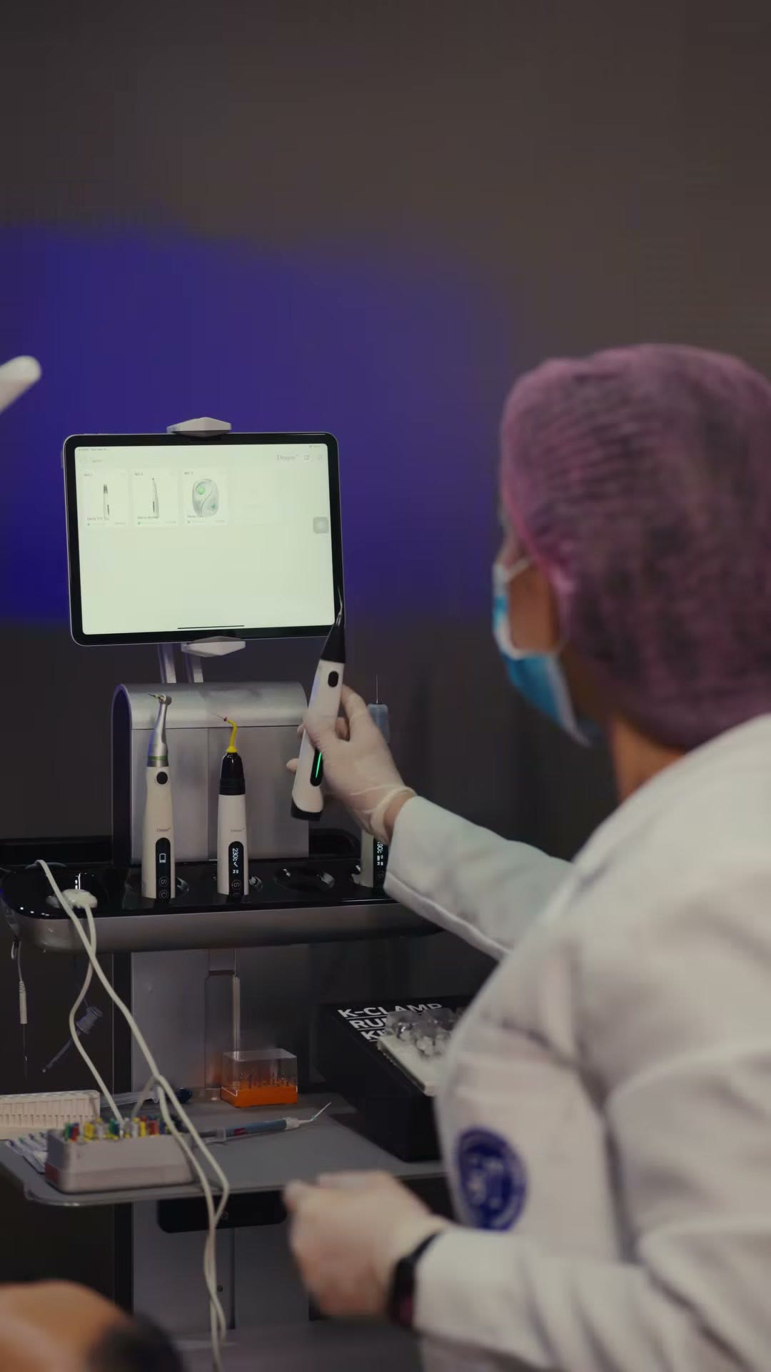 The dentist returning to the workstation cart mid procedure