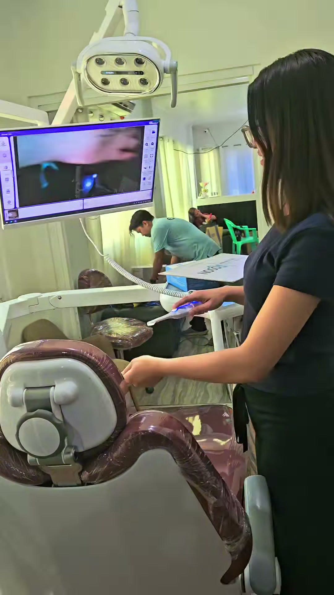 The dentist at the chair with an intraoral view on the monitor
