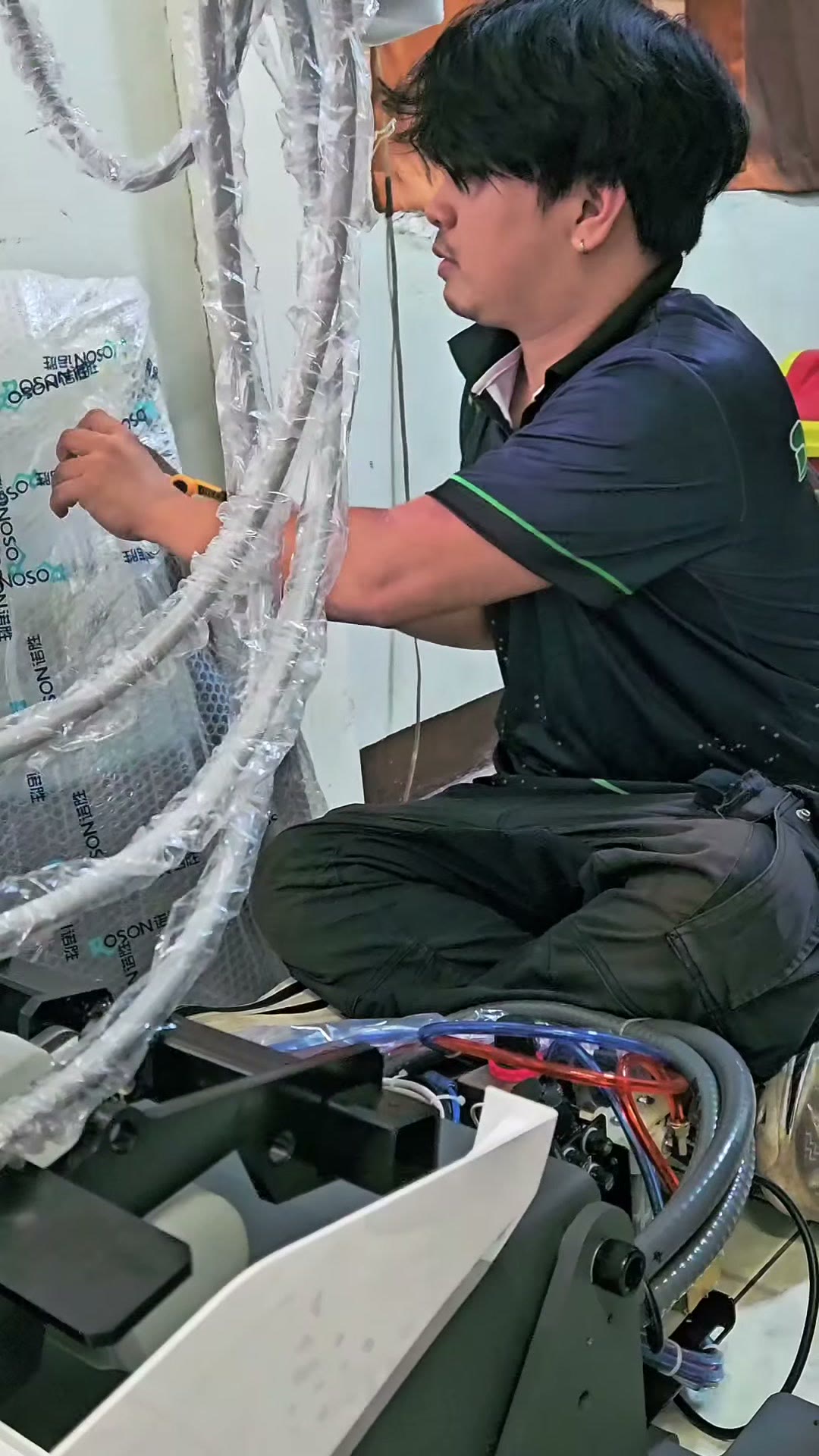 Technician wiring the underside of the delivery unit