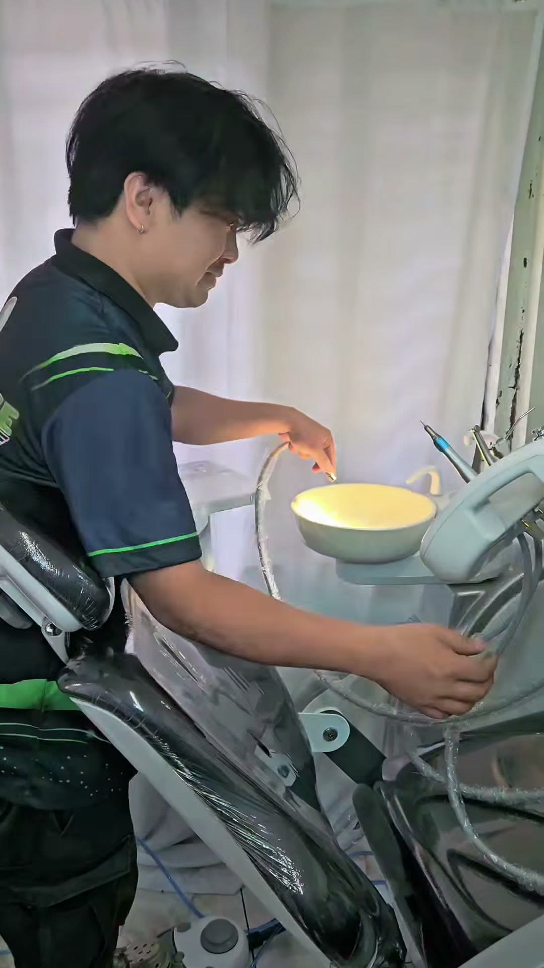 Technician adjusting the spittoon on the installed chair