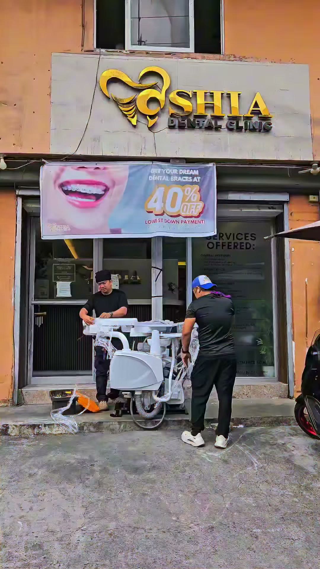 Two technicians bringing the dental unit into the street-front clinic