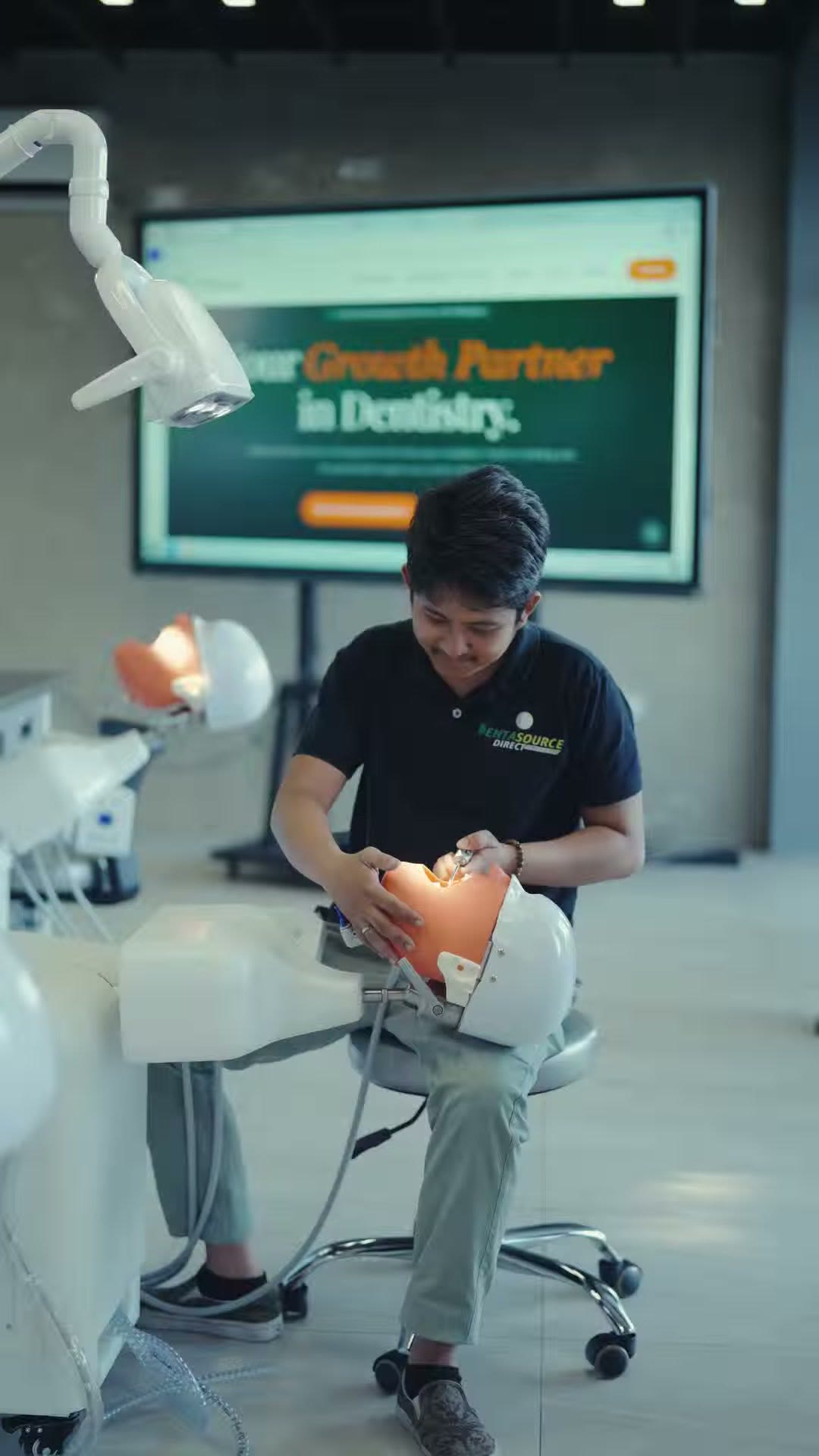 A trainee working on a phantom head under the operating light