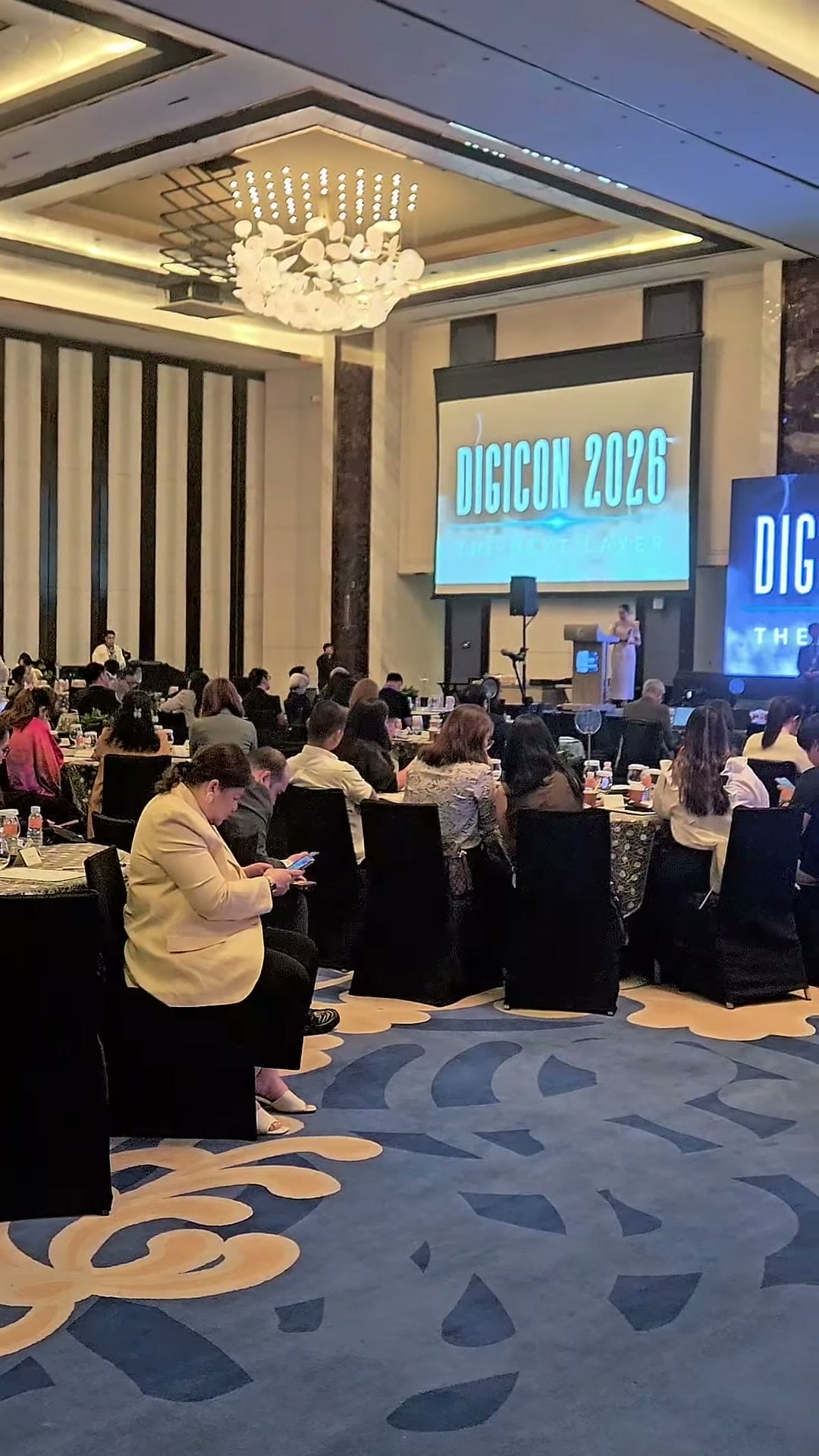 The DIGICON 2026 stage with delegates seated at round tables