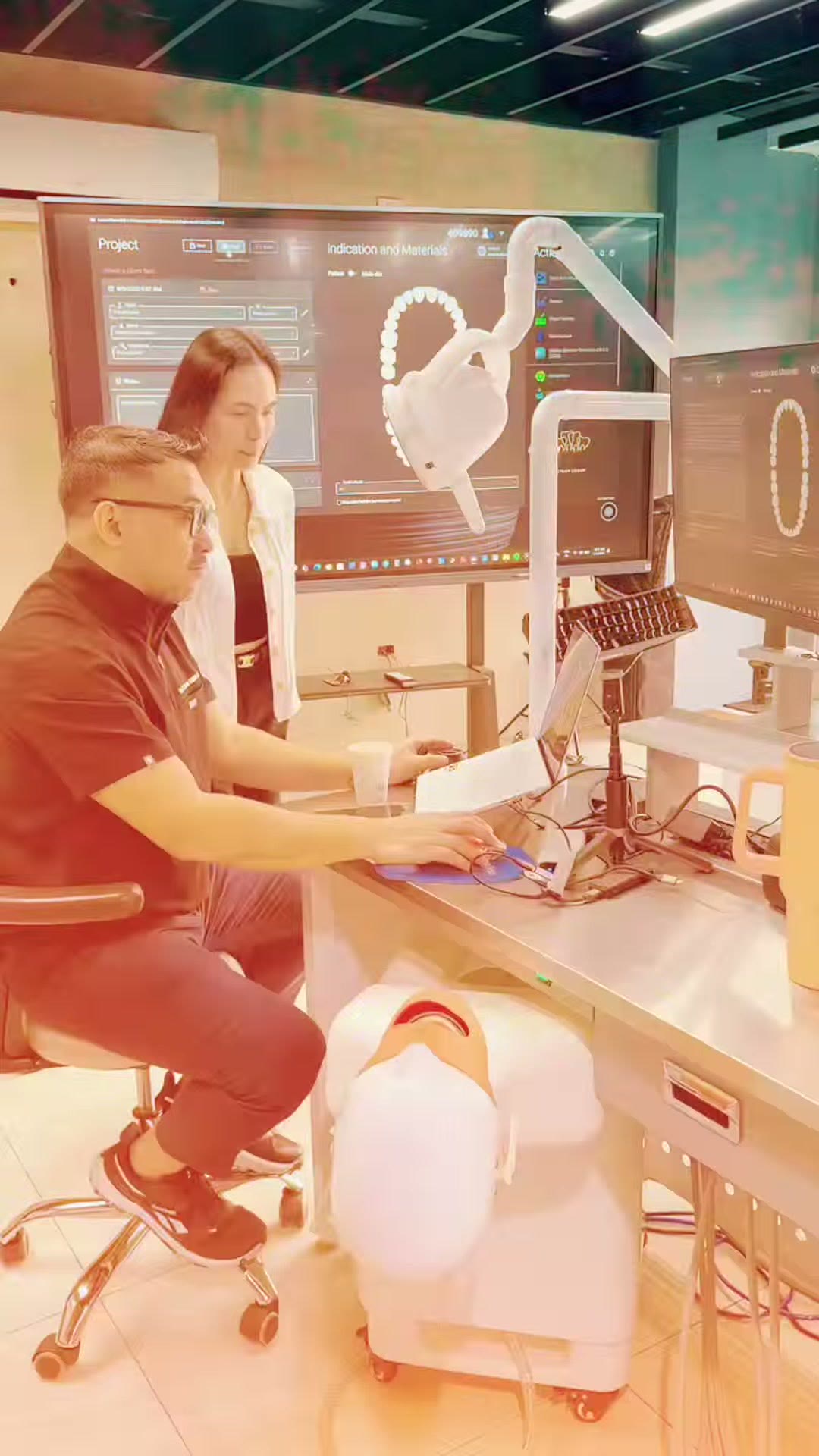 The instructor at the CAD screen beside a phantom head station