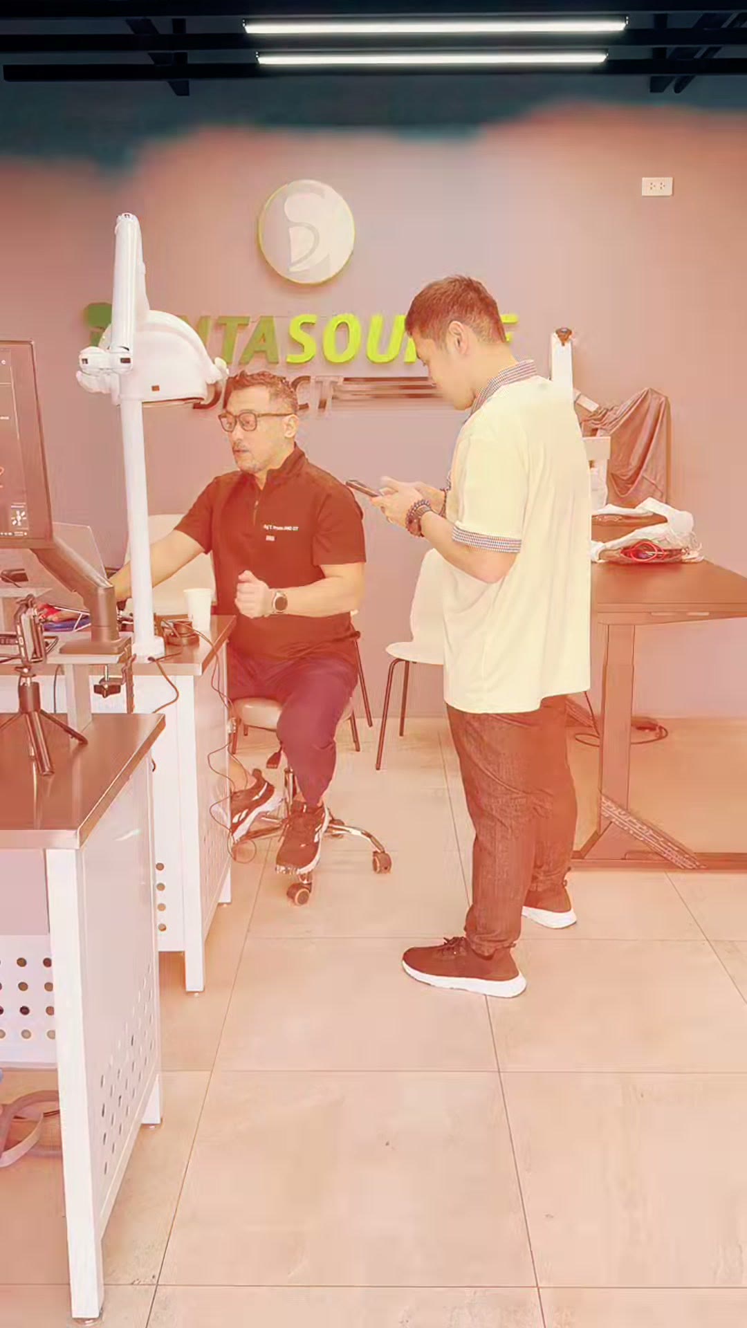 The instructor talking a trainee through a step under the DentaSource sign