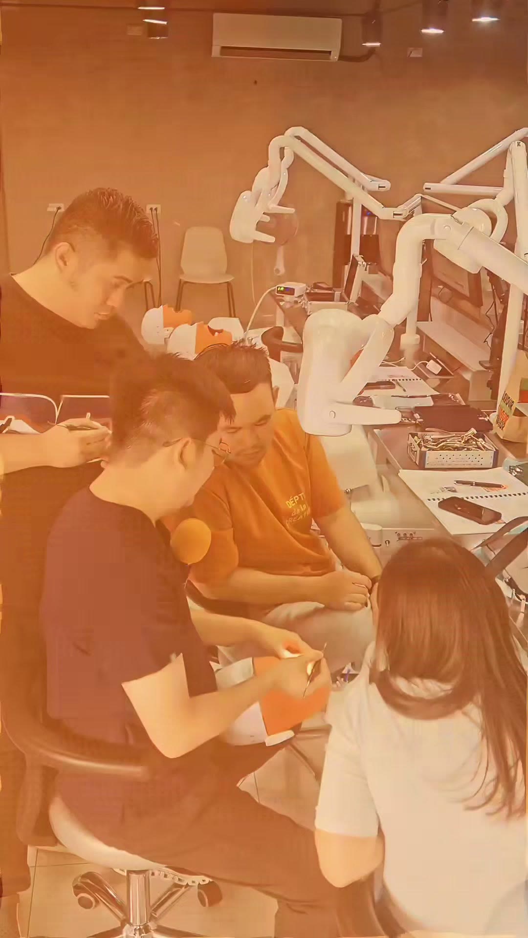 The instructor at the surgical microscope with trainees watching