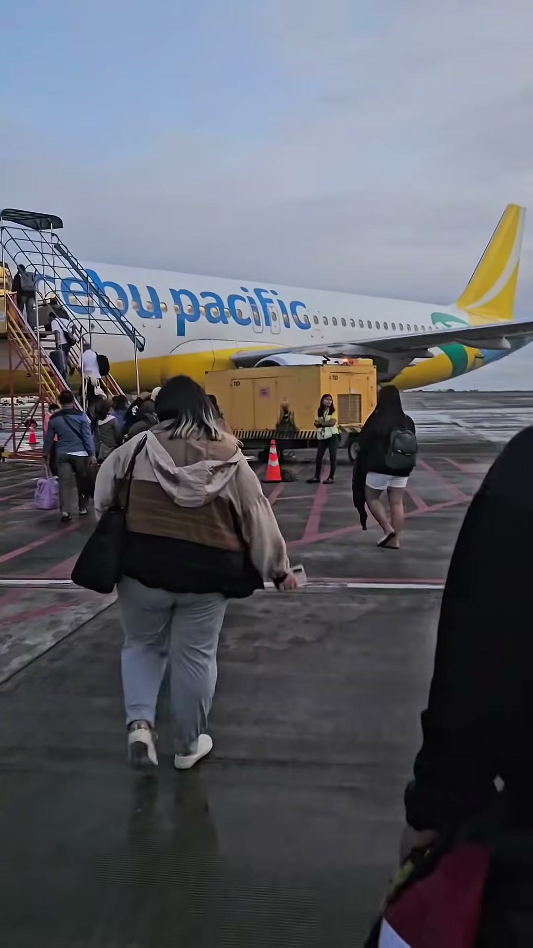 Boarding the aircraft on the tarmac with the booth cases checked in