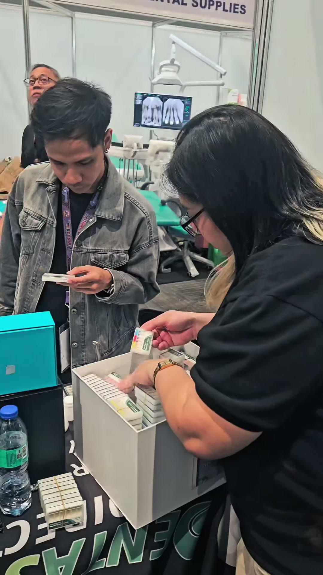 A dentist and our staff at the counter going over product boxes