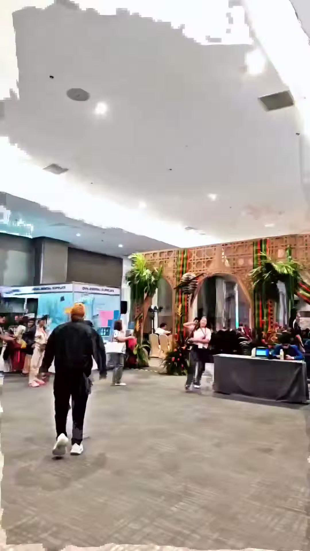 Walking toward the booth past the palm decorated hall entrance