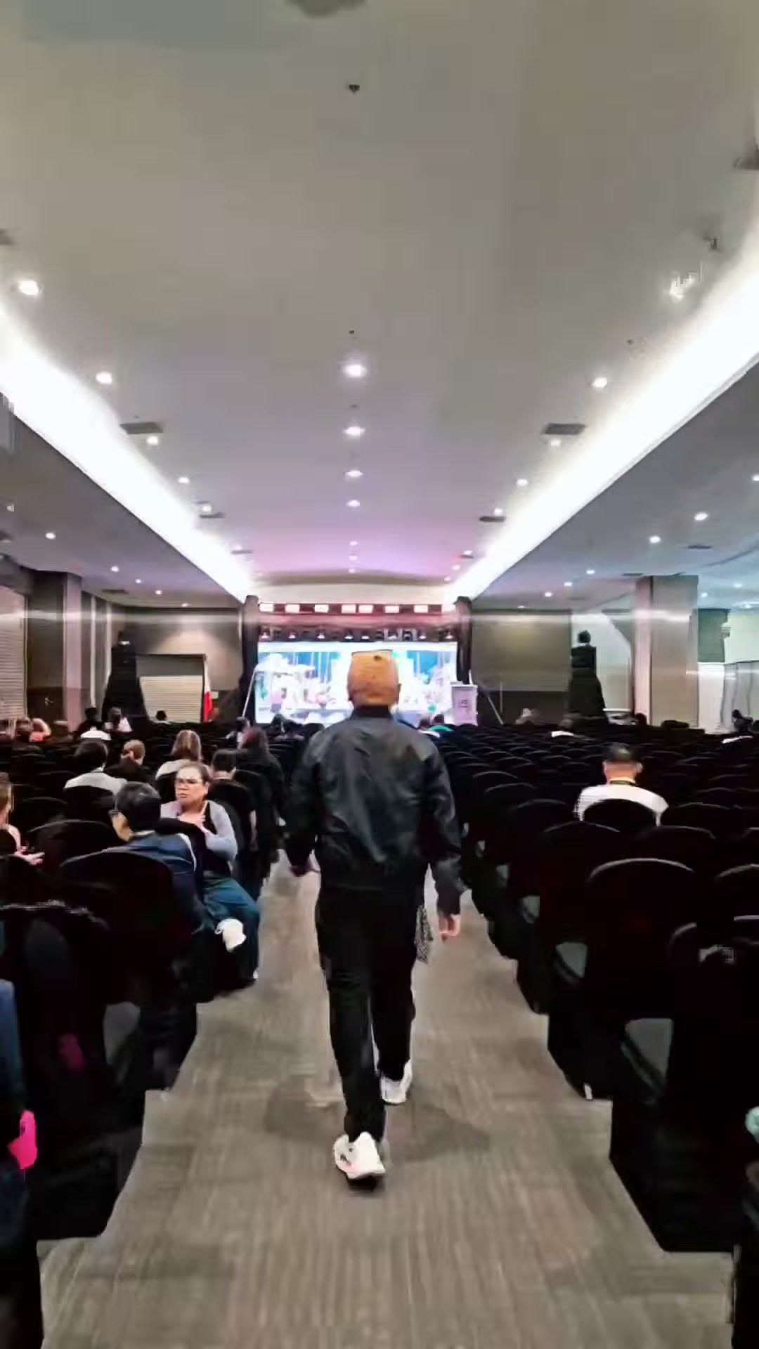 Walking down the aisle of the packed plenary hall