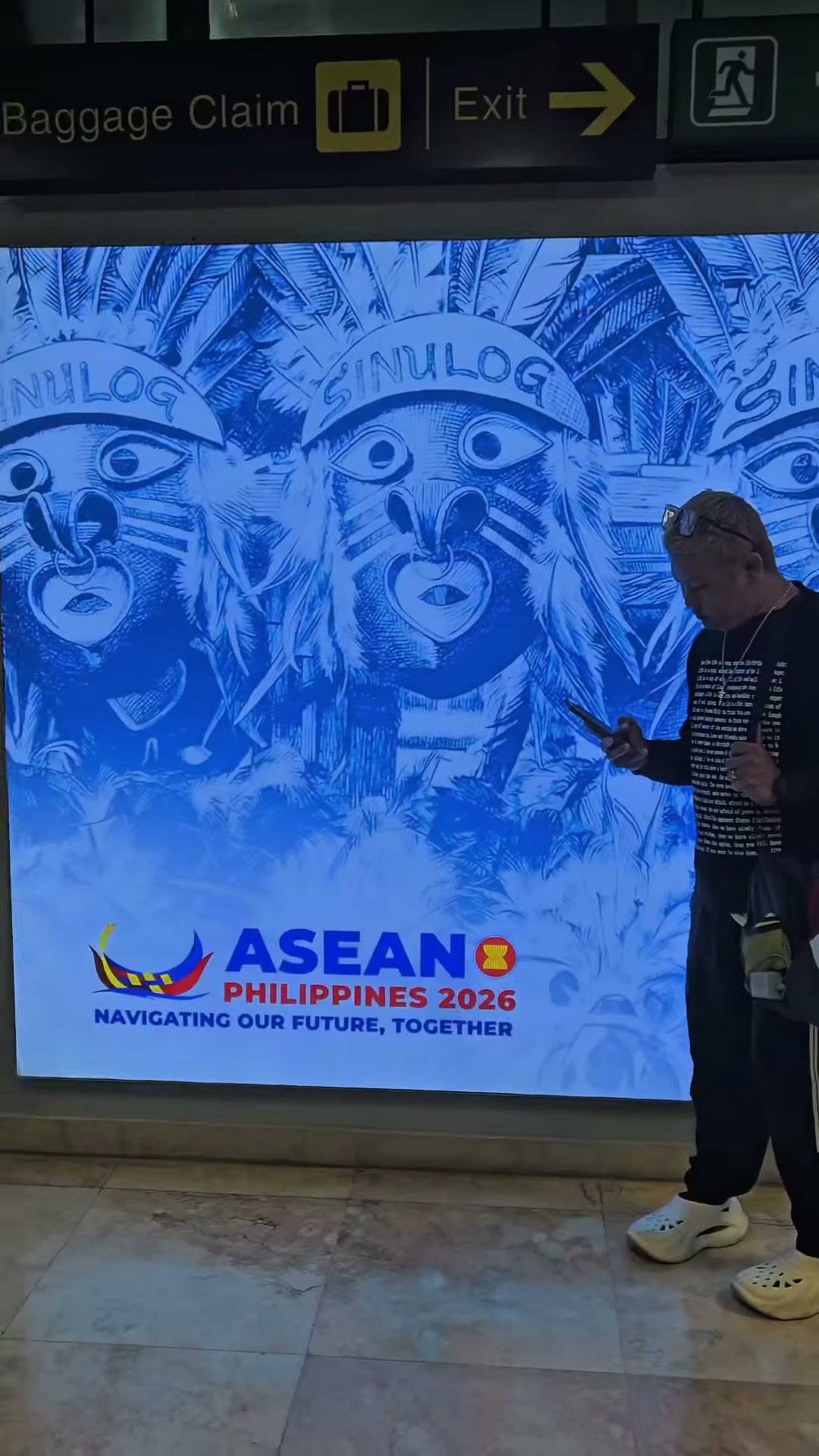 Our staff beside the mural at the airport before the flight home