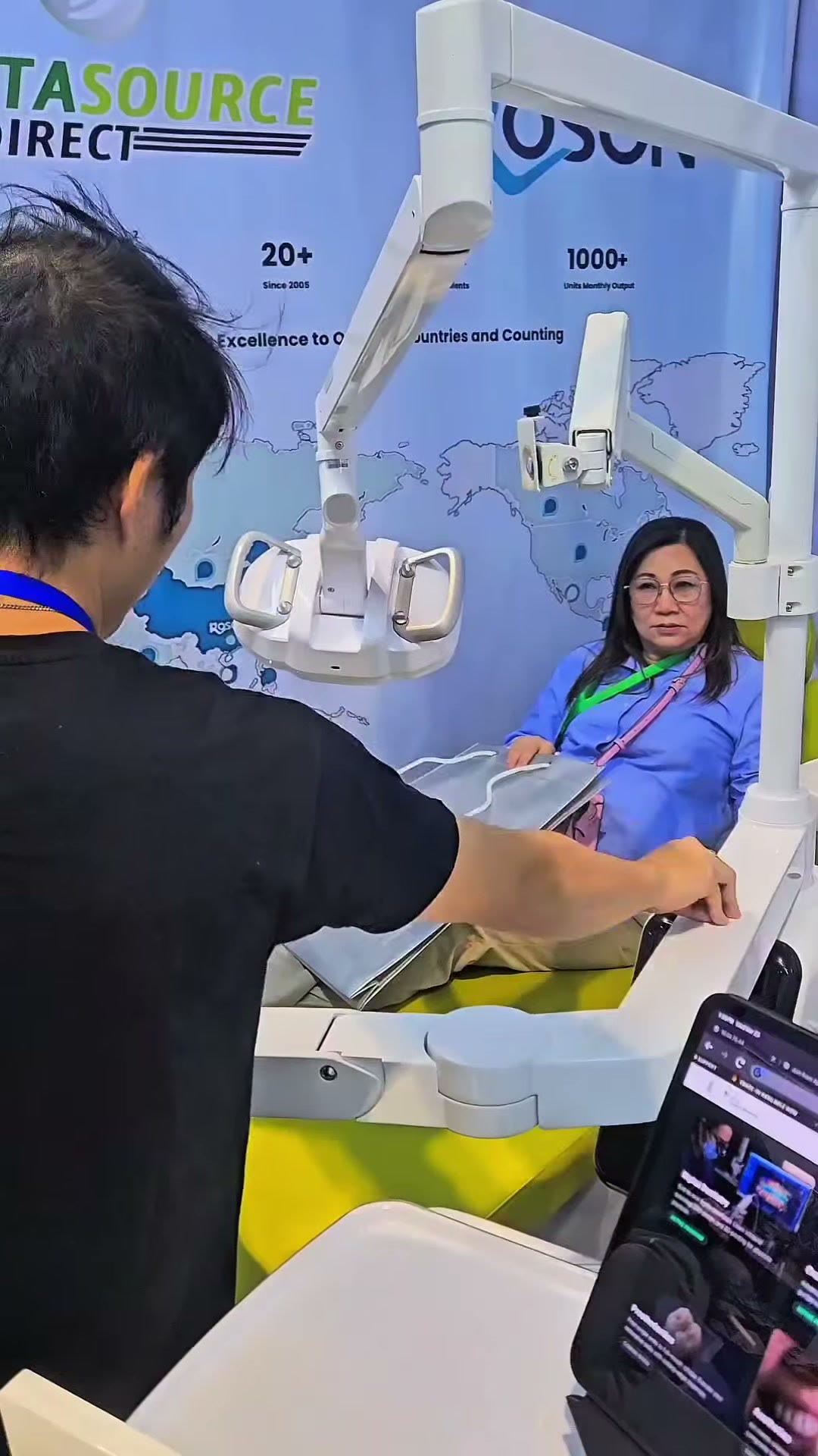 A dentist seated in the ROSON display chair while our technician runs the demo