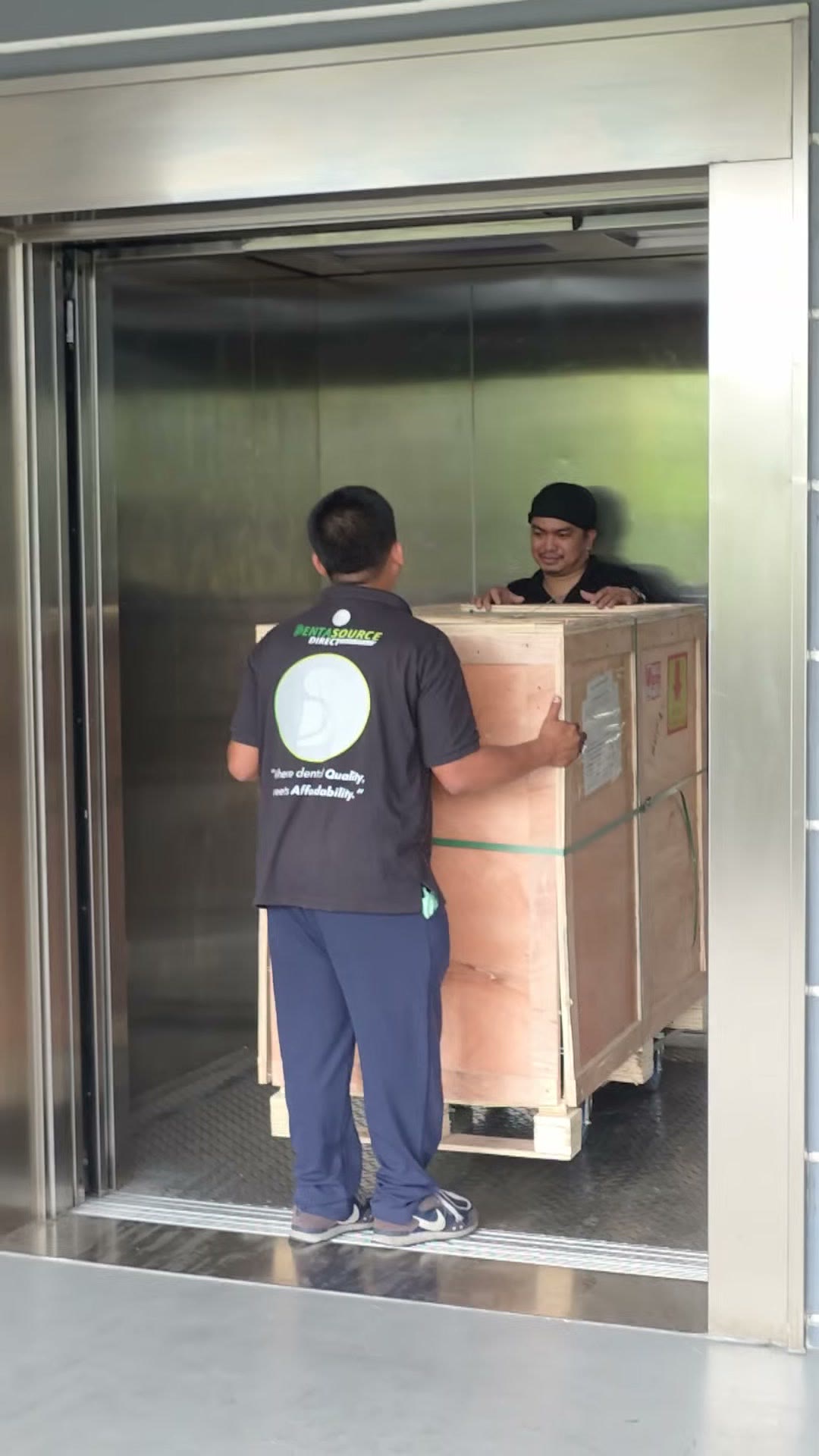 The team pushing a large crate across the warehouse floor