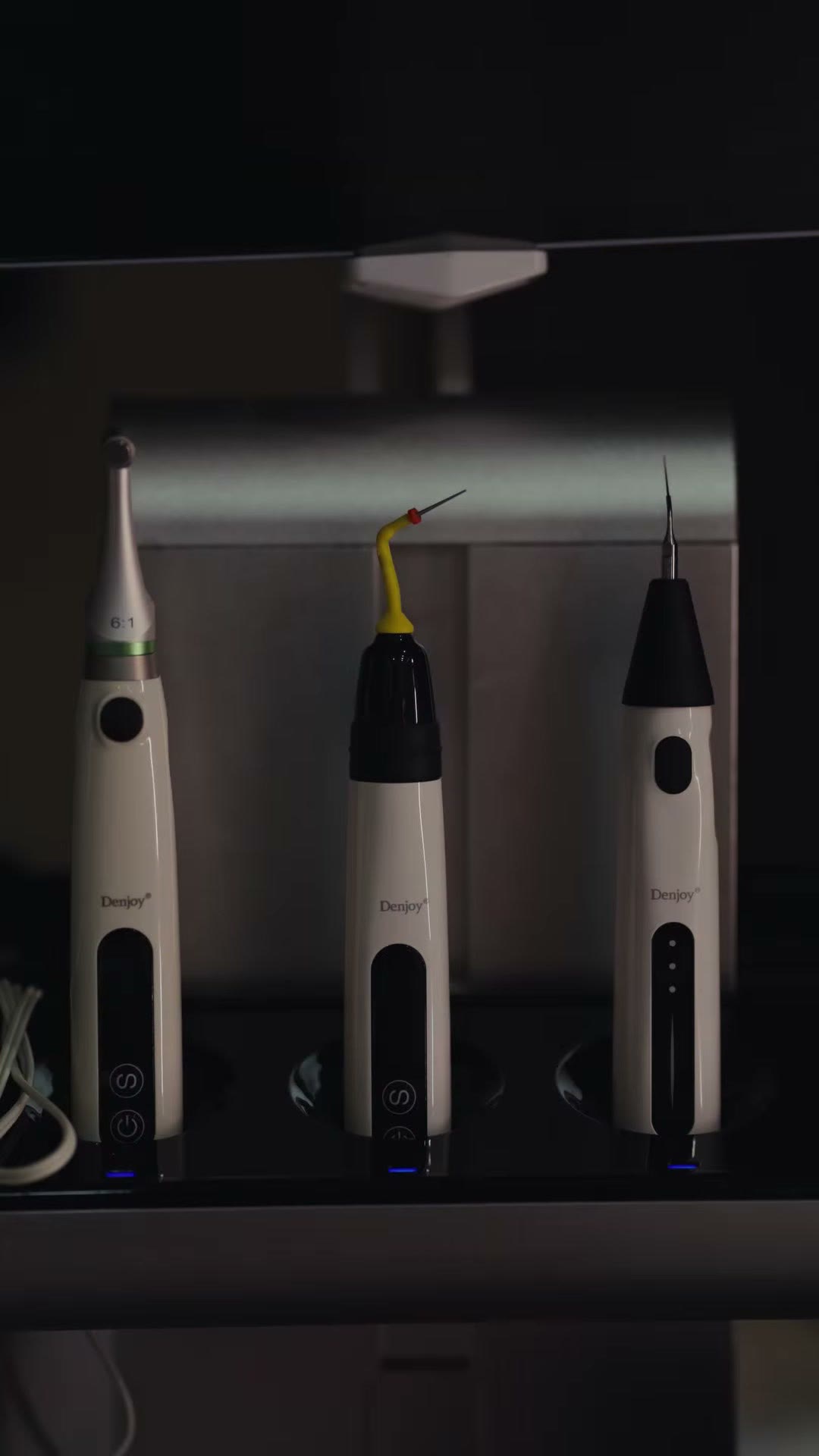 Three Denjoy endodontic units resting on their charging dock