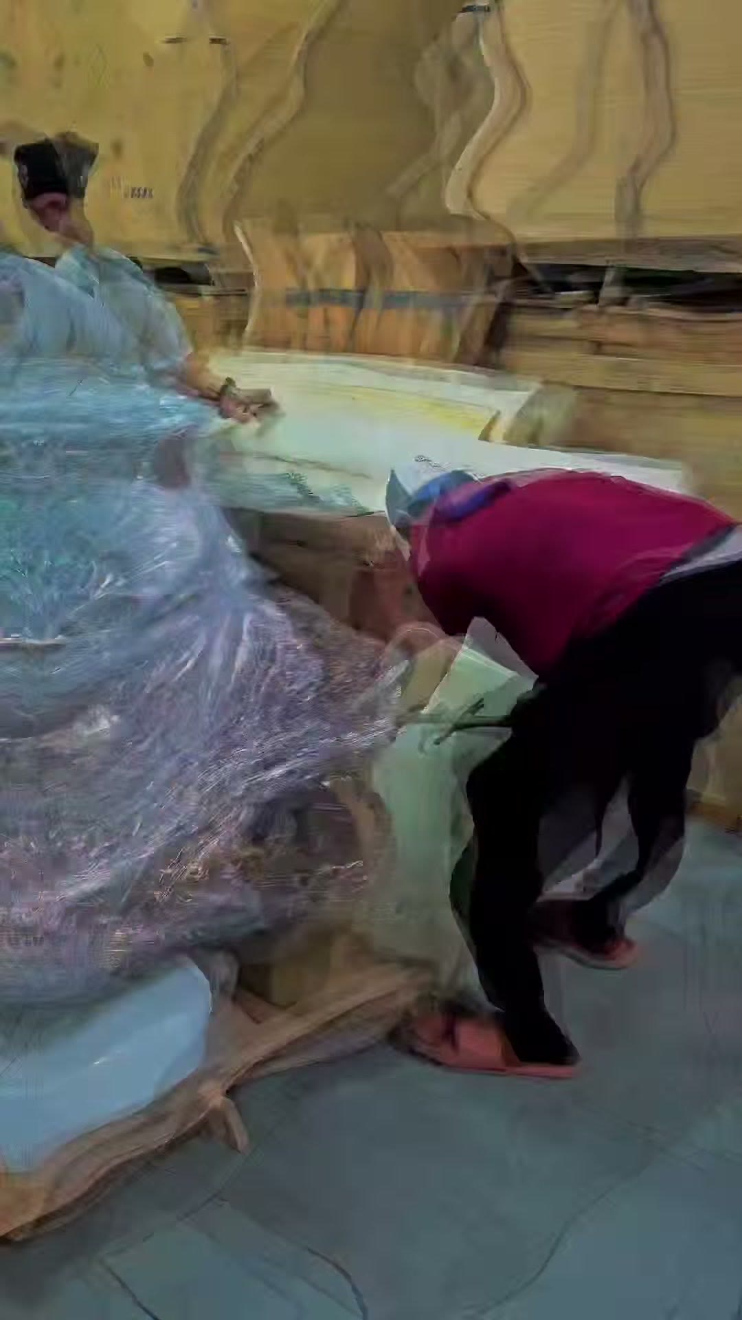 Our technician bent over a shrink wrapped unit in the warehouse