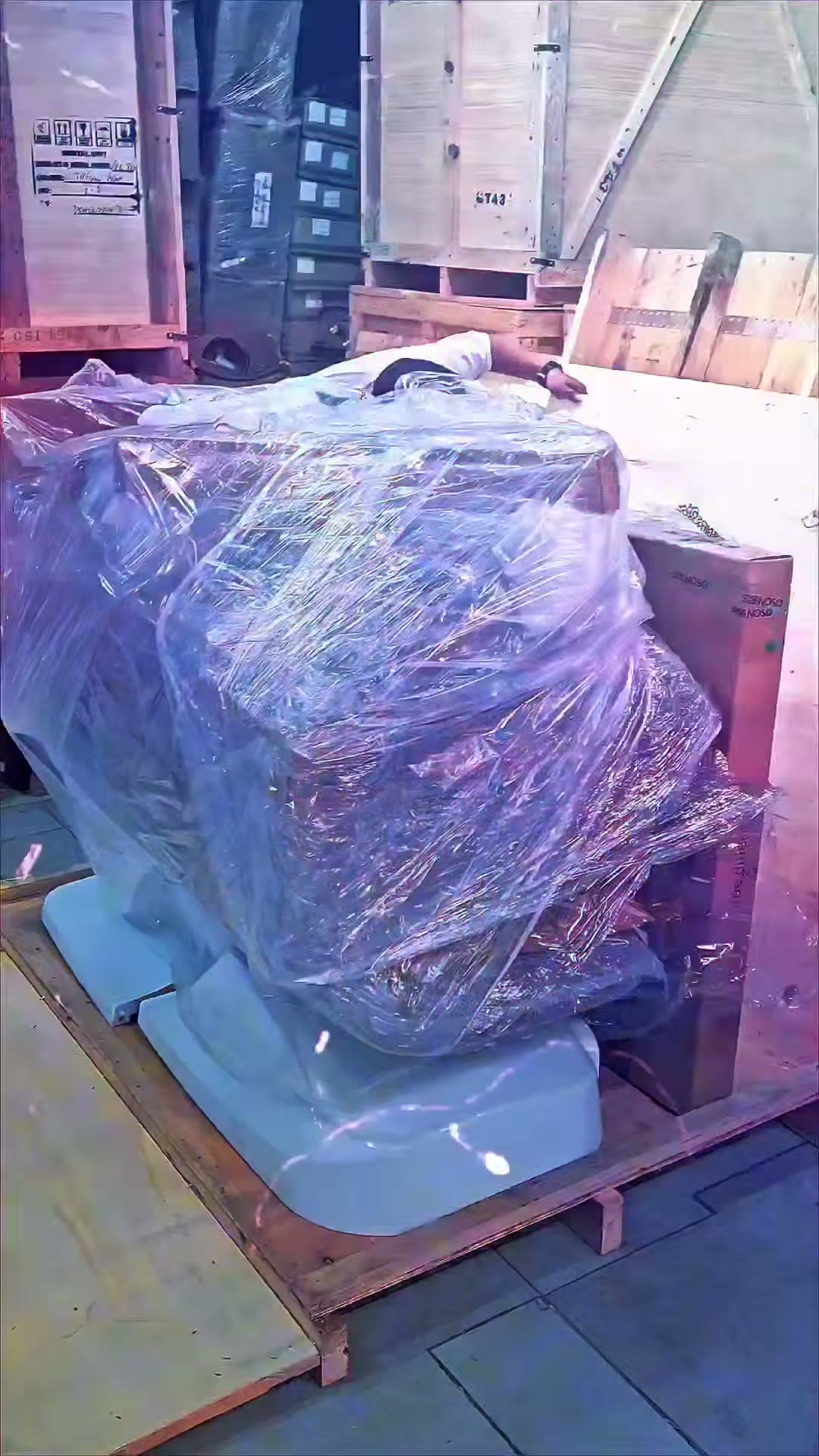 The wrapped chair on its pallet among the delivery crates