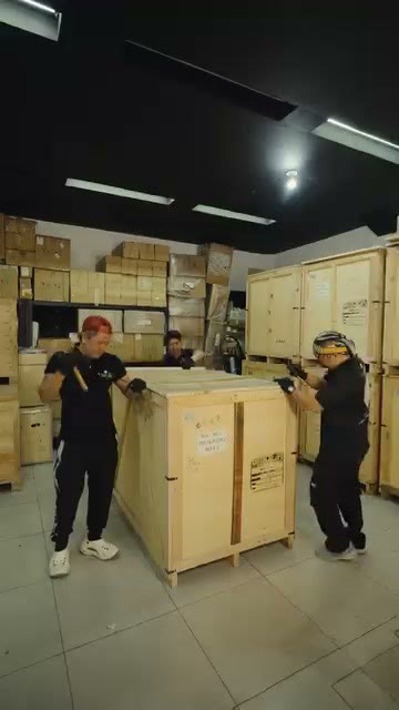 The team beside a sealed crate on the warehouse floor