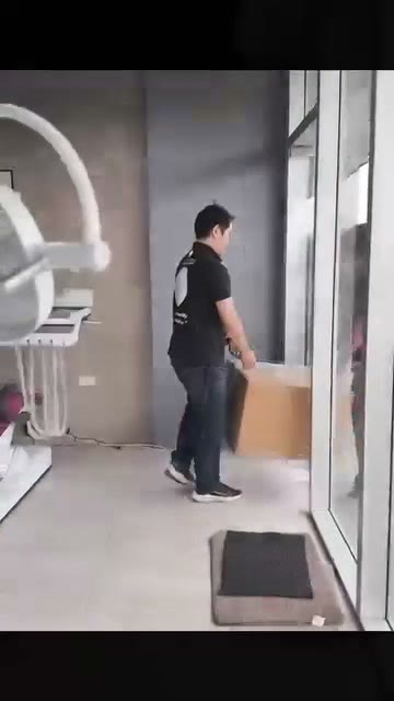 Technician carrying a boxed unit out through the showroom door