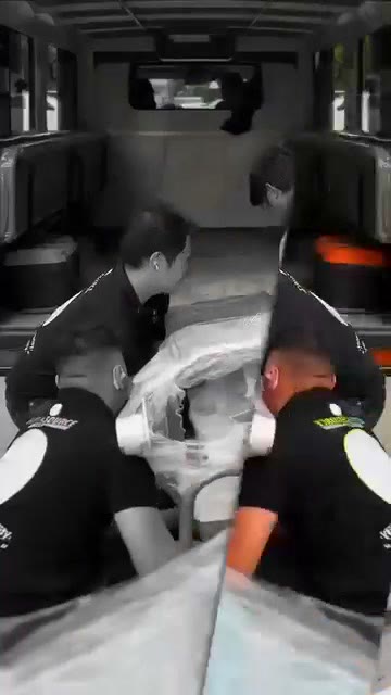 The team easing the wrapped chair into the delivery vehicle