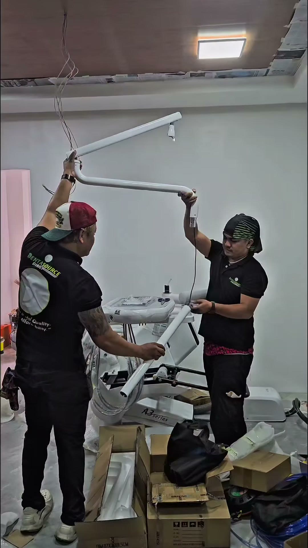 Two technicians lifting the counterbalanced light arm into position