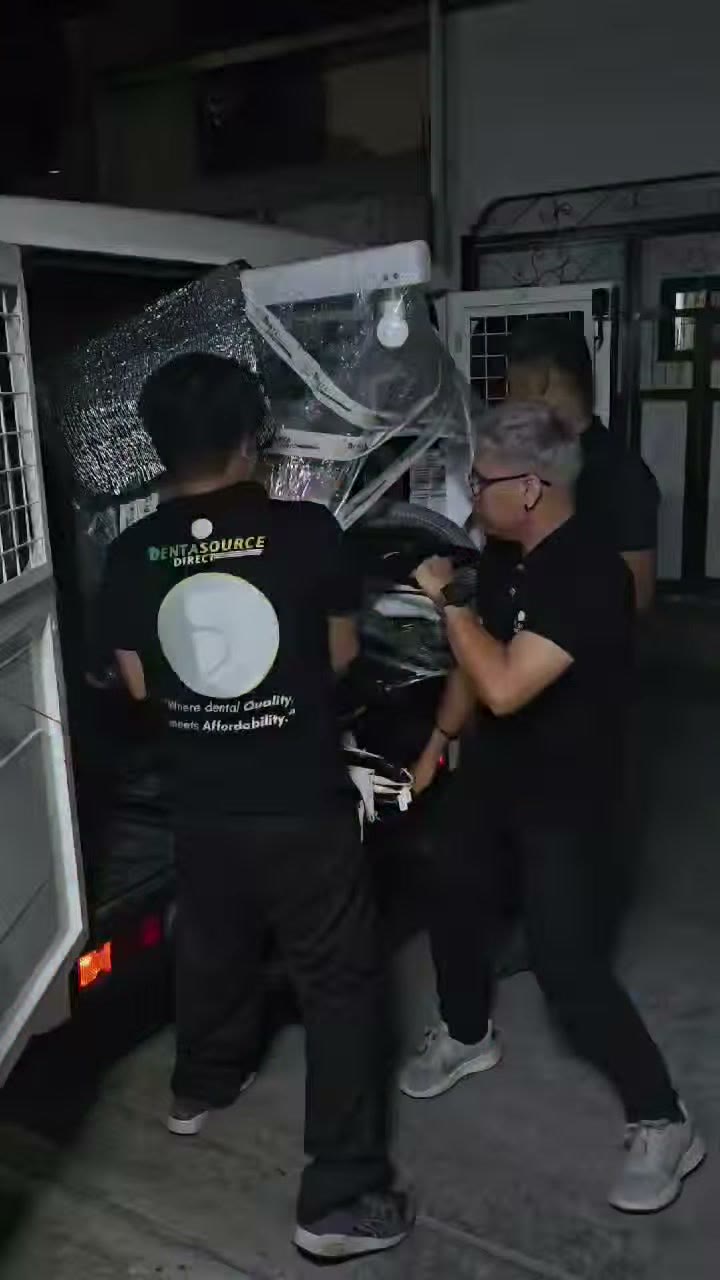 The crew lifting the wrapped unit out at night