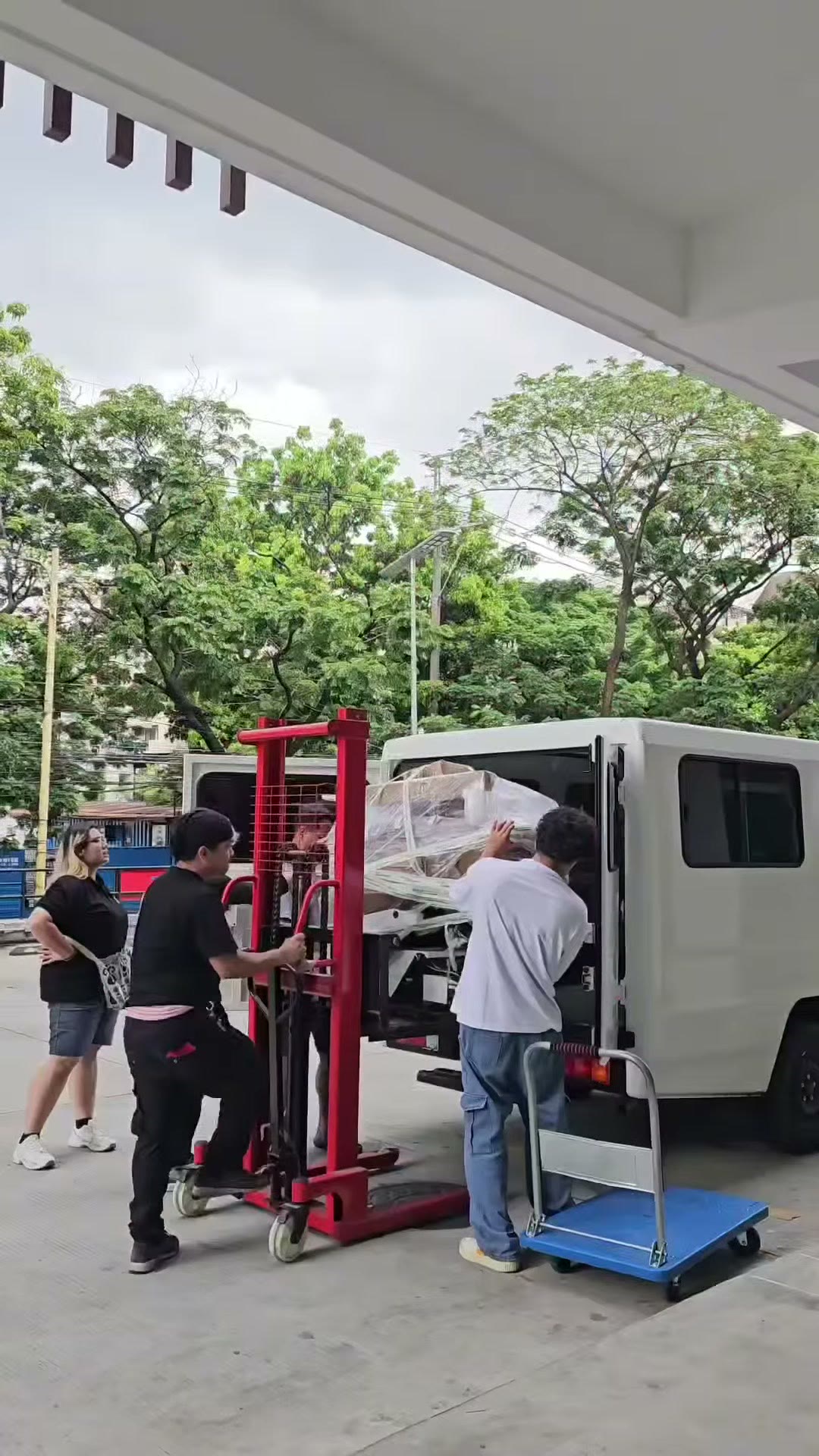 A hydraulic stacker lifting the wrapped chair off the delivery truck