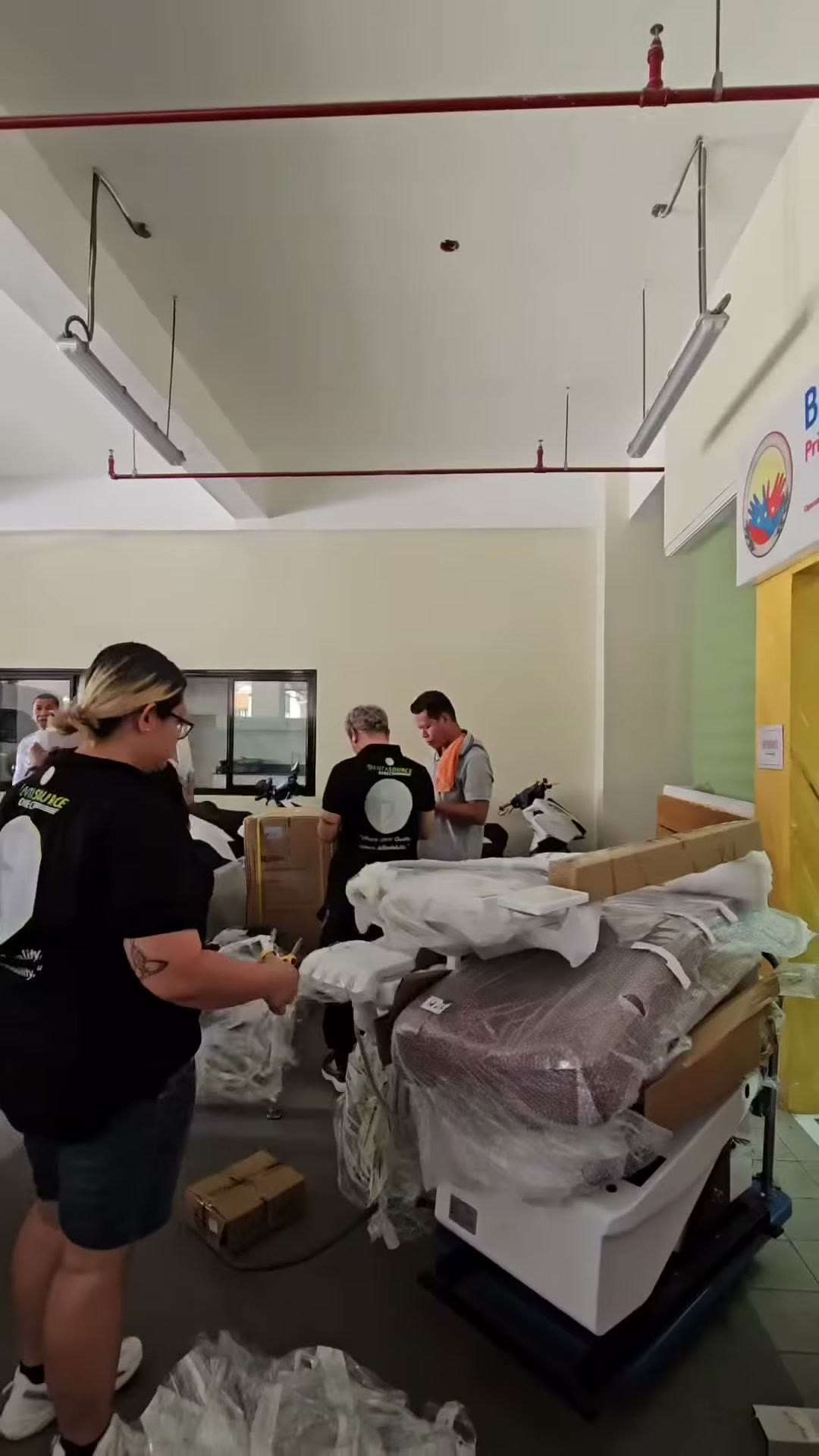 Our crew unwrapping the chair base in the covered hall