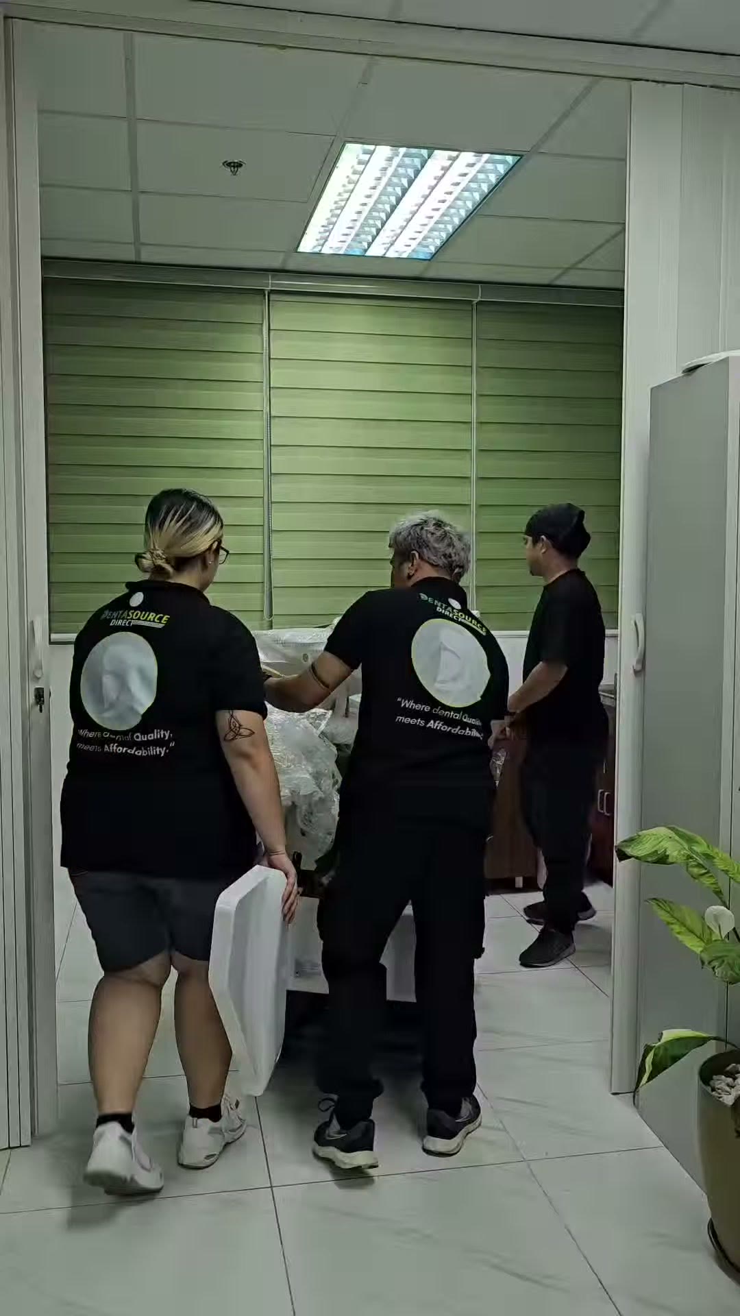 The team carrying chair parts through the clinic doorway