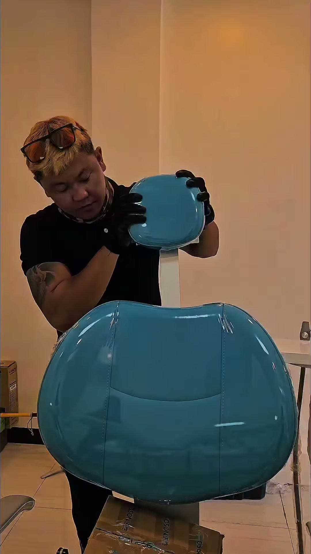 Carrying the blue backrest cushion in to be fitted