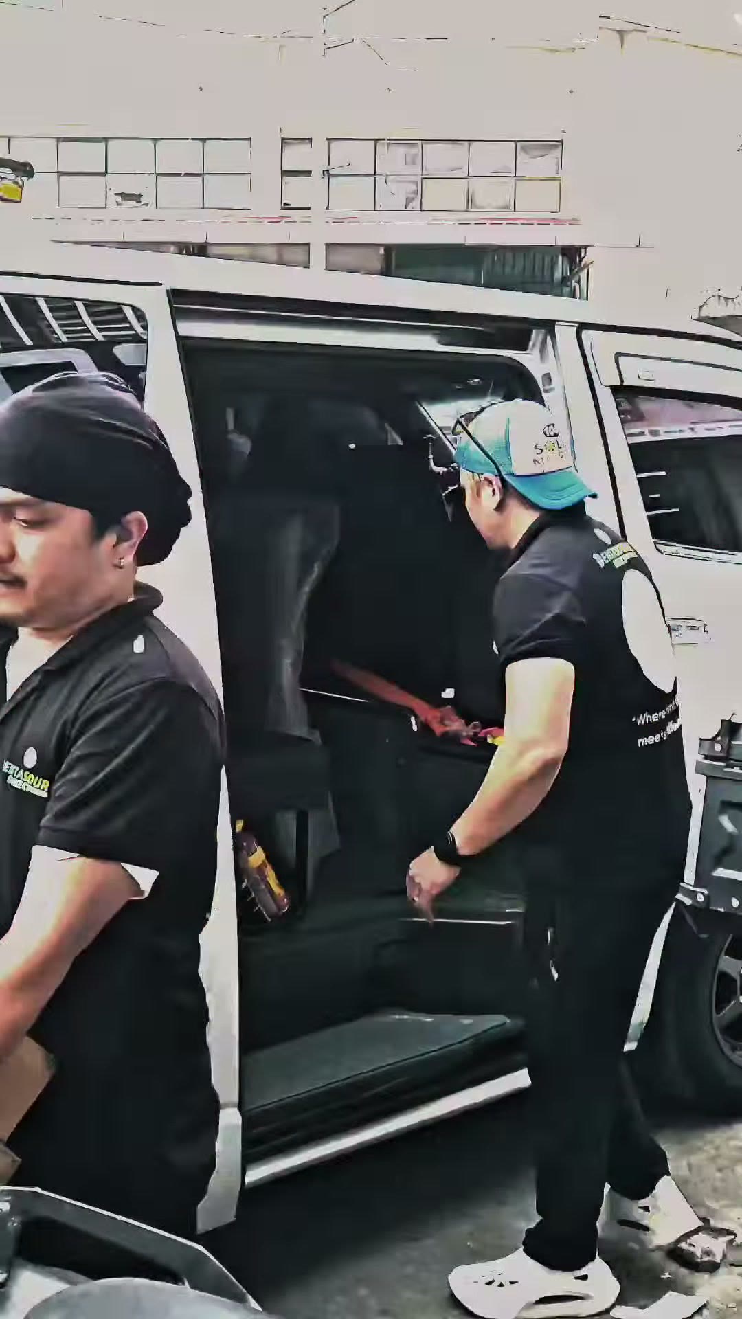 Two technicians working at the open van door