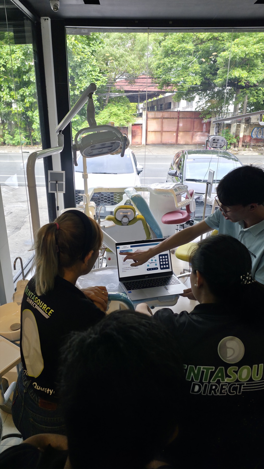 The DentaSource team gathered around ROSON's specialist for the user preference settings walkthrough