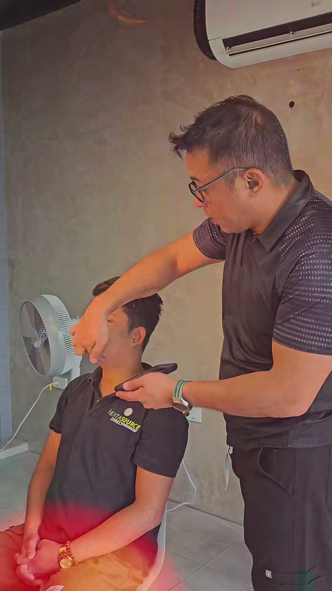 The instructor positioning a volunteer's head for the portrait
