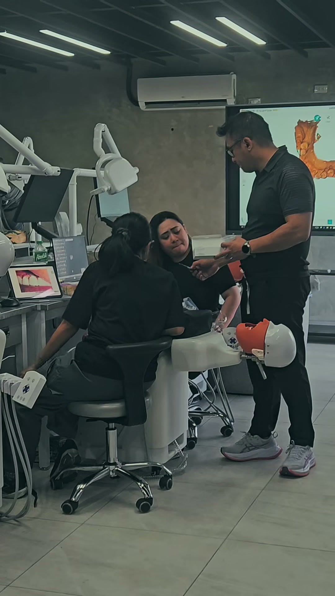 The instructor examining a volunteer in the dental chair