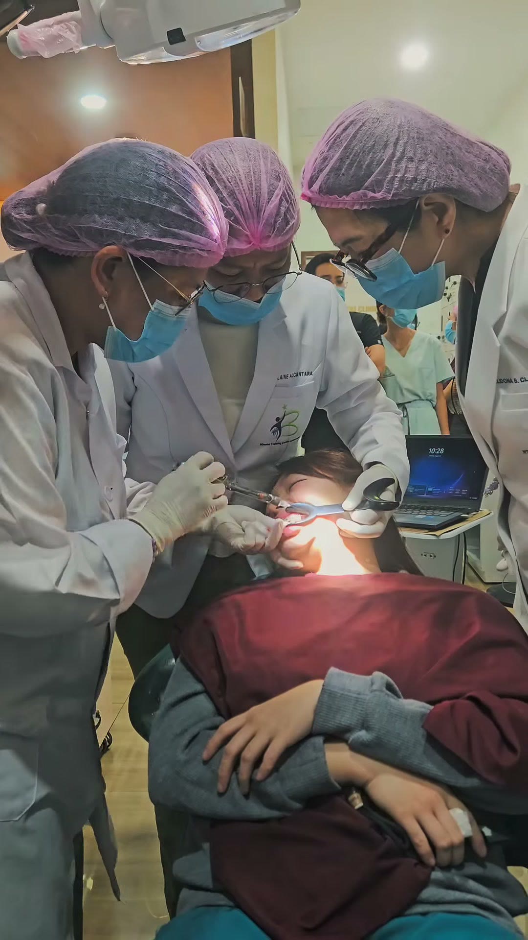 Three clinicians working together around the patient during placement