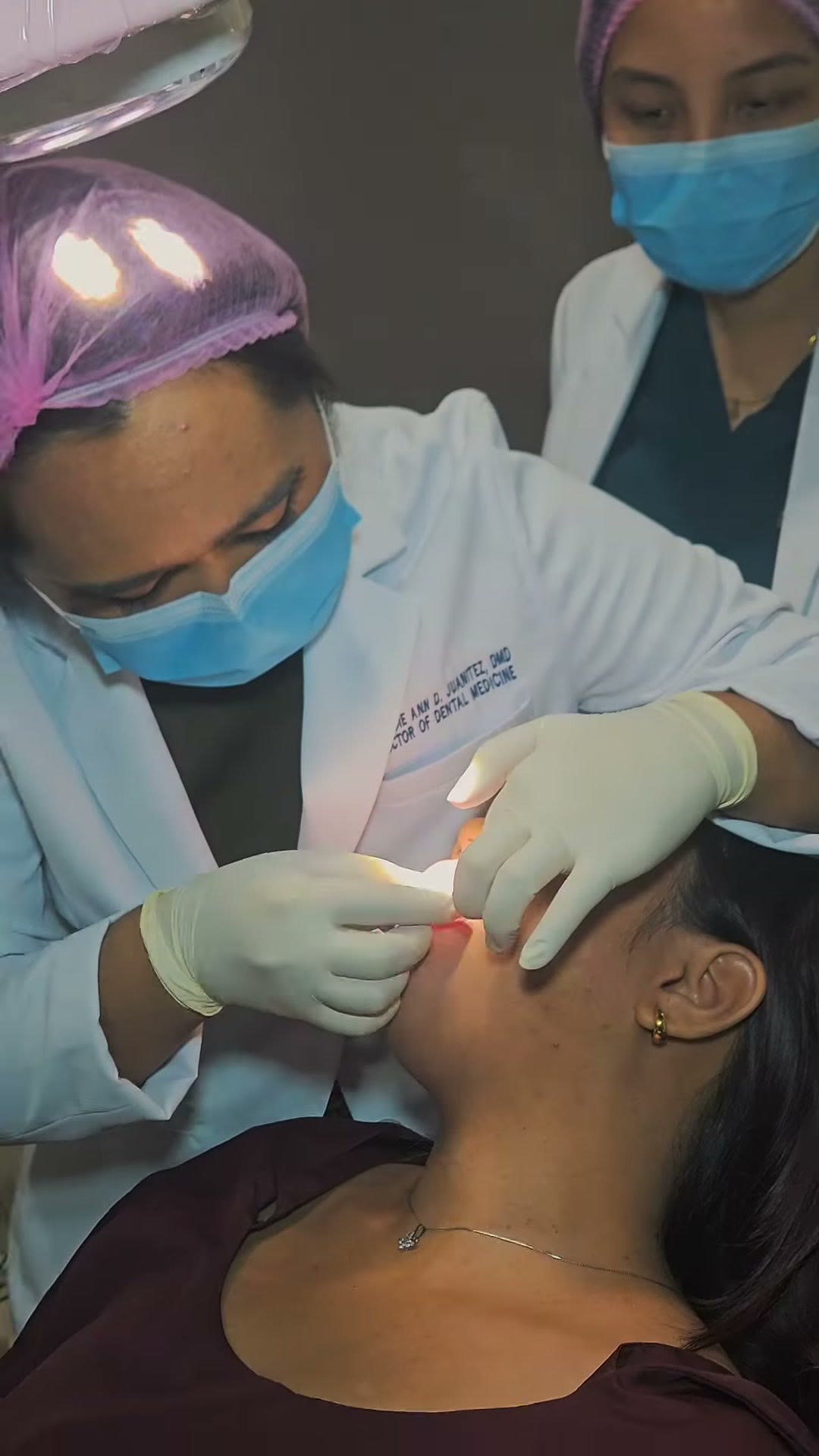 The instructor guiding the trainee's hands through the placement