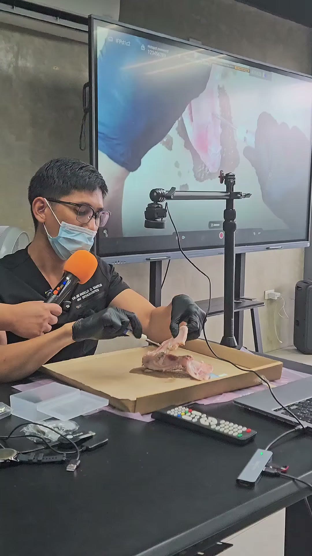 A participant practising screw insertion on a pig jaw model under a camera rig